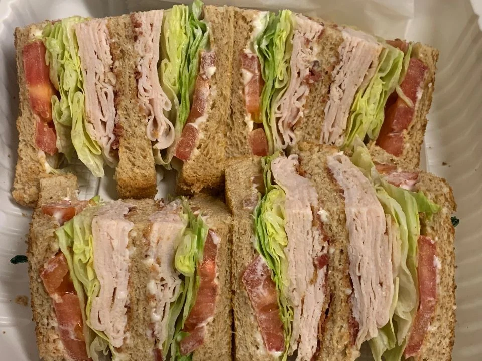 Pastore’s Turkey Club, cut into quarters with oven-roasted turkey, lettuce, tomato and bacon on toast